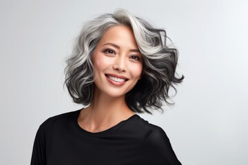 Portrait of a happy mature asian woman on a gray background. Facial skin care concept, anti-aging cosmetics, cosmetology
