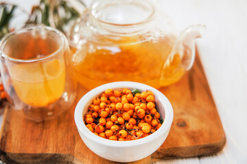 sea buckthorn tea in a clear glass teapot, a natural elixir.