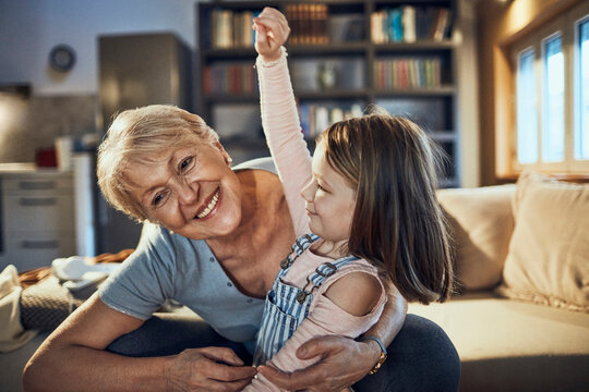 Grandmother watching a movie with granddaughter in the living room