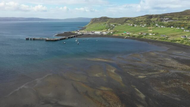 Aerial drone view of little harbour on the coast of Scotland on a sunny day