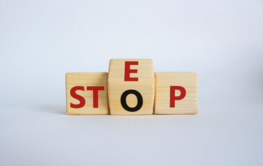 Step vs Stop symbol. Wooden cubes with words Stop and Step. Beautiful white background. Step vs Stop and business concept. Copy space