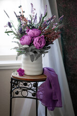 Still life purple flower bouquet in white vase by window
