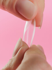 Step-by-step instructions for nail extension on gel tips. Manicure, hands in the foreground. Pink background. Copy space