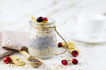 Oatmeal in a jar (lazy oatmeal) with bananas and chia seeds. Healthy breakfast concept.