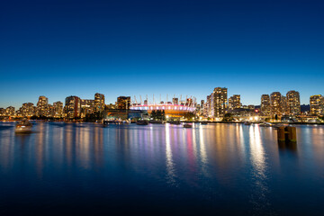 A long exposure photo during blue hour of the Vancouver Skyline from False Creek with the BC Place...