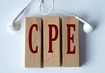 CPE - acronym on wooden blocks on white background with wired headphones