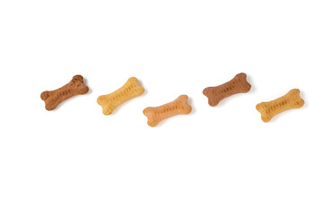 Dry biscuits for treating dogs in the shape of a bone on a white background