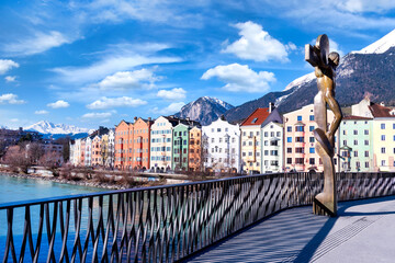 Cityscape of Innsbruck city center with beautiful houses, river Inn and river bridge with sculpture...