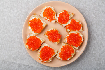 Sandwiches with red caviar on the table on a white tablecloth