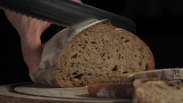 Cutting slice of homemade Crusty rye bread