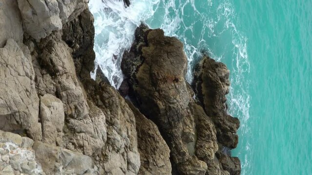 Waves break on the coastal cliffs. Nice, Bay of angels (Baie-des-Anges), Provence, Cote d'azur, France