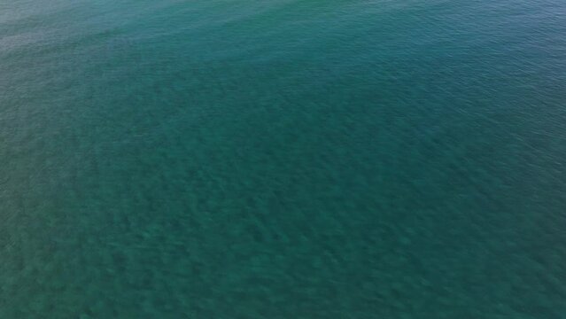 Blue sea or ocean water surface and underwater with sunny and cloudy sky, Blue water with ripples on the surface. Defocus blurred transparent blue colored clear calm water surface texture