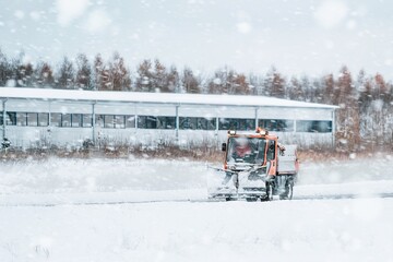 Tractor with mounted salt and sand spreader, road maintenance - winter gritter vehicle. Municipal...
