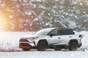 Winter’s embrace holds no barrier for this powerful SUV as it glides through the snowy terrain with grace and power showcasing man’s conquest over nature. White truck car on the winter snowy road.