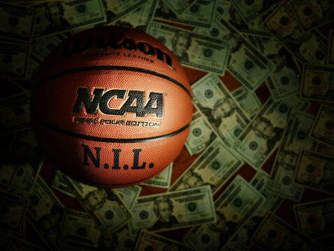 Eveleth, MN - USA - 03-08-2022: An NCAA Final Four basketball with NIL text surrounded by money
