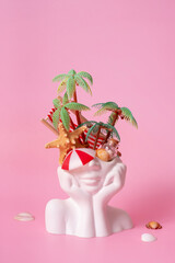 Plaster head with dreaming about vacation. Palms, beach chair and shells overhead. Vacation creative concept.