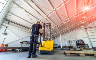 Warehouse worker loading pallet with forklift into truck