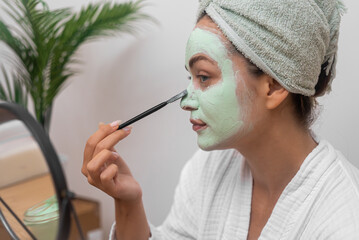 Glowing Beauty: She graces her face with a moisturizing mask, nurturing her skin's health and beauty in the comfort of home. 