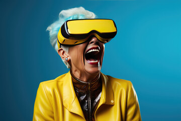 Portrait of happy elderly woman wearing virtual reality glasses on a blue background. Concept of using modern technology by elderly people.Copy space for text - obrazy, fototapety, plakaty