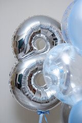 silver number 8 and set of blue helium balloons on white background