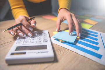 a person sitting at a table with papers and a pen