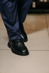 The image shows a person wearing black boots while standing indoors 6039.