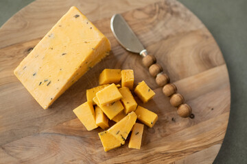 English cheddar cheese on a wooden board from above with a cheese knife.
