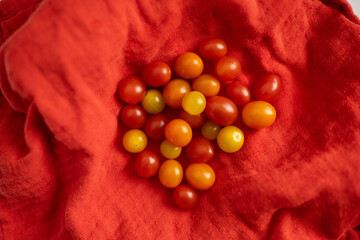 Cherry tomatoes in a variety of colors in a red cloth