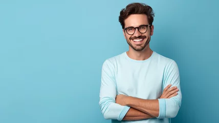 Tuinposter Portrait of young smiling man wearing glasses isolated on turquoise background with space for inscriptions or text © bahija