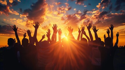 Silhouettes of a Crowd with Hands Raised Toward a Glowing Sunset Sky - obrazy, fototapety, plakaty