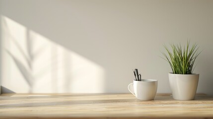  a couple of white cups sitting on top of a wooden table next to a potted plant on top of a wooden table with a white wall in the background.