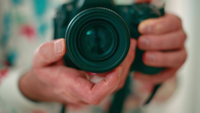 Man holding a camera shooting in the mirror. Rotating focus ring