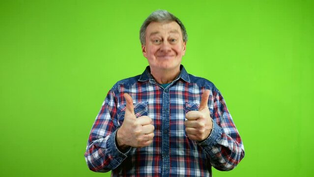 Senior man pointing herself and looking to camera shows thumbs up im best.