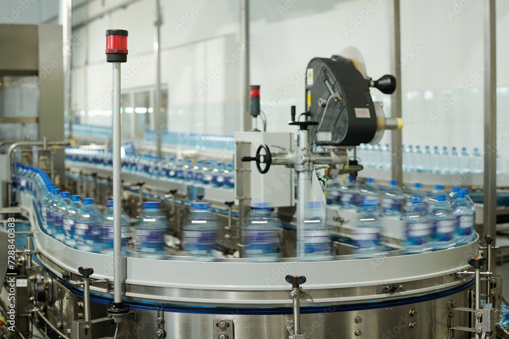 Aufkleber blurry motion of production line with group of capped plastic bottles with filtered still or carbona