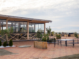 Indoor restaurant on the seashore. Public catering. A restaurant with a fence and lanterns on it. Wooden building.