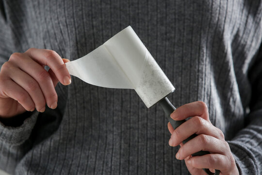 Hair remover roller. Woman using reusable clothes lint roller cleaner.