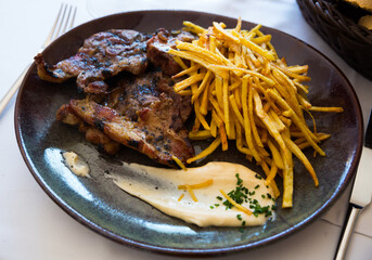 Appetizing roasted lamb meat with French fries and white sauce