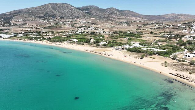Aerial drone video of famous for surfers sandy beach of Chrysi Akti or Golden beach with crystal clear emerald sea calm with no wind, Paros island, Cyclades, Greece