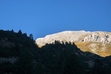 Mt. Vihren summit illuminated by rising sun. View from the Vihren hut in summer morning.