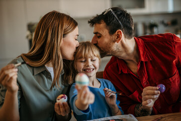 Mom, dad, and daughter immerse themselves in festive decorations together
