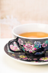 Hot green tea in black floral pattern porcelain teacup