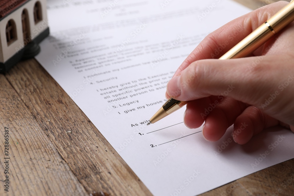 Canvas Prints Woman signing Last Will and Testament at wooden table, closeup