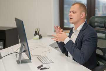 Caucasian deaf man uses sign language for online negotiations.
