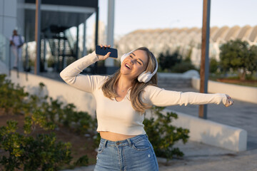 CHICA ALEGRE Y SONRRIENTE BAILANDO EN LA CALLE CON CASCOS