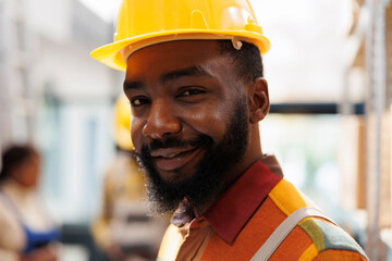 Smiling african american young warehouse handyman face portrait. Freight storehouse operator...