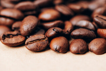 Roasted coffee beans on beige background. Closeup, copy space