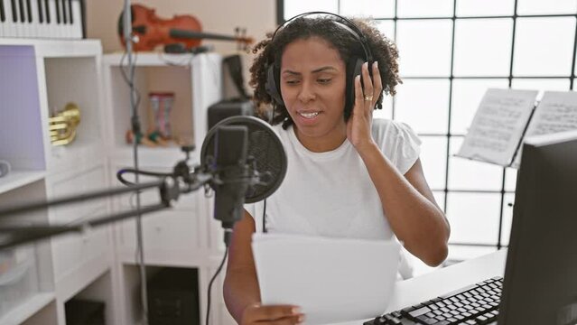 African american woman recording music in studio