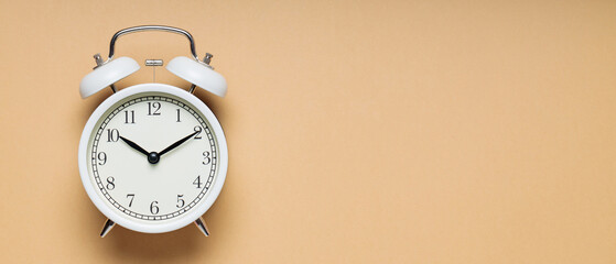 White Vintage Alarm Clock on Beige Background, Time and Change Concept, Copy Space