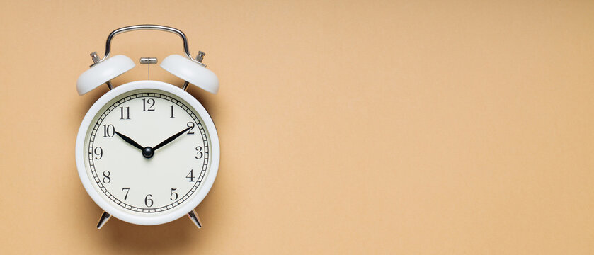 White Vintage Alarm Clock on Beige Background, Time and Change Concept, Copy Space