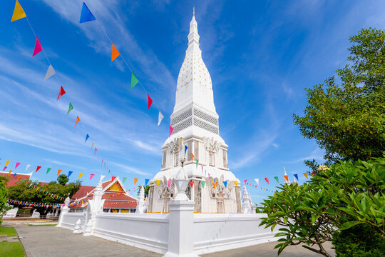 White gold pagoda with blue sky and white cloud background, Wat Phrathat Tha Uthen is a Buddhist temple in the Tha Uthen District, Nakhon Phanom Province, Isan region of Thailand near the Lao border.